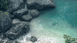 An aerial view of a beach with rocks and water.