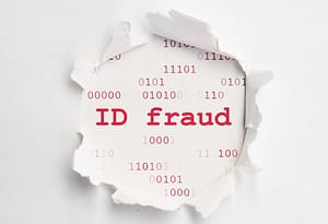 A torn piece of paper with the words "id fraud" written on it, serving as a reminder to lock down your financial identity and examine your money habits.