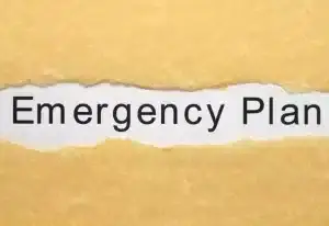 A ripped piece of paper with the word emergency plan, serving as a reminder for creating a solid financial security with an emergency fund