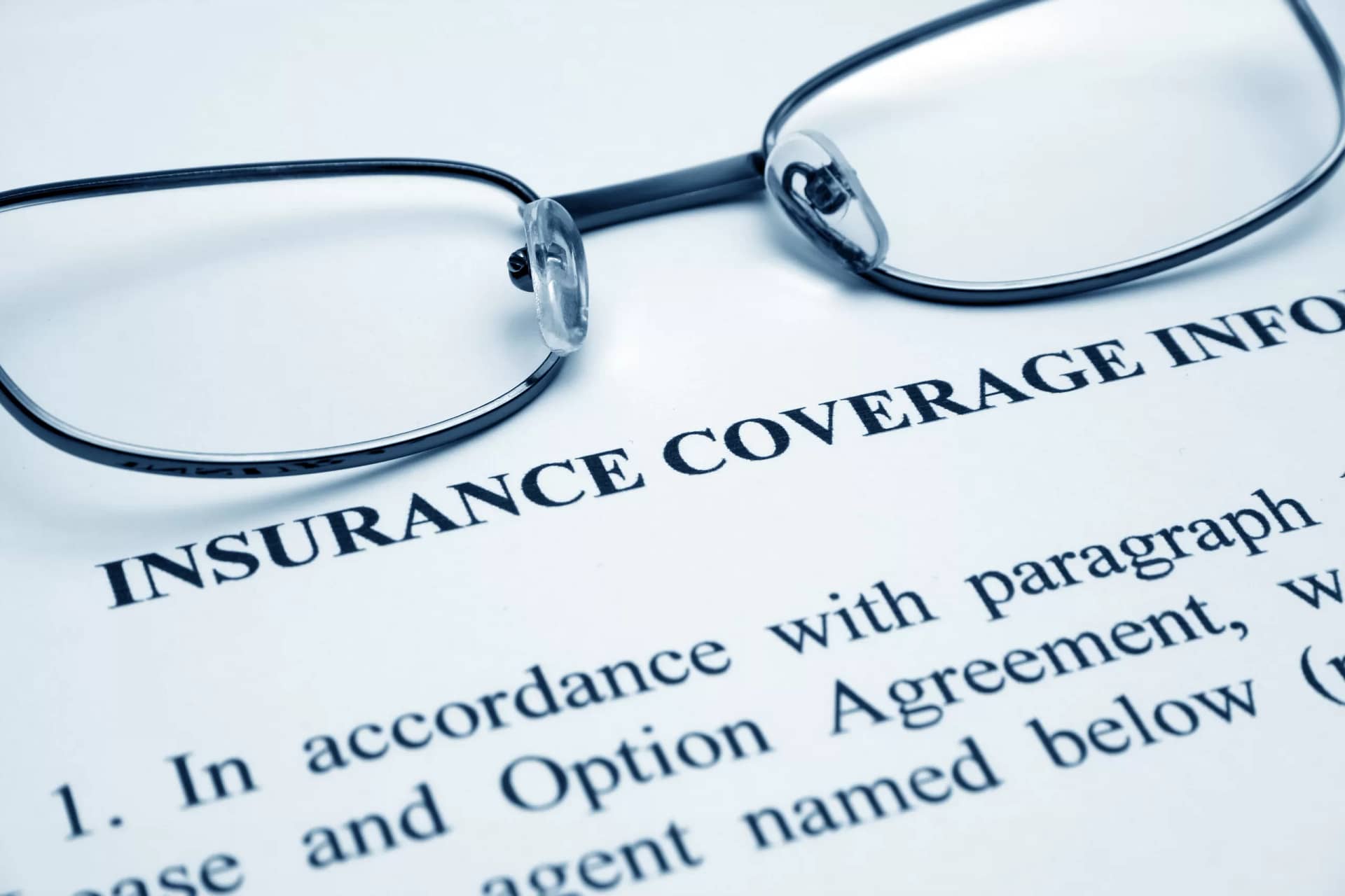Eyeglasses on a document with the word insurance coverage information.