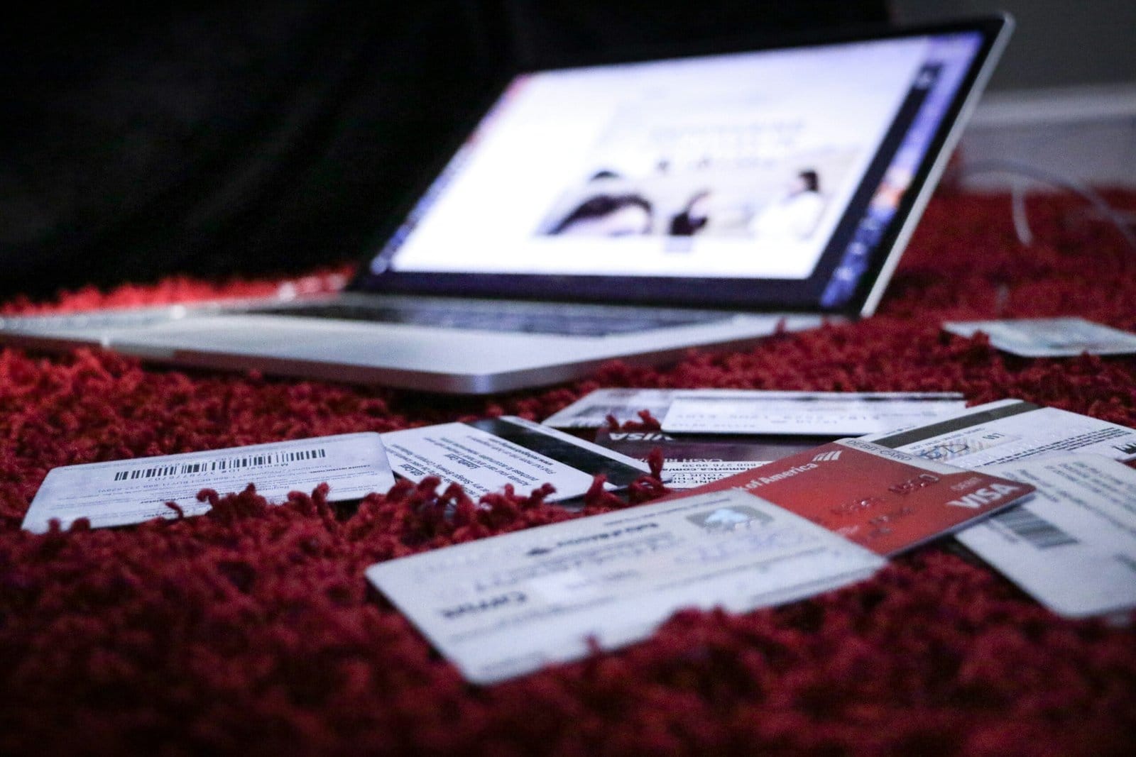 A laptop is sitting on a red carpet with tickets on it. New Credit Score